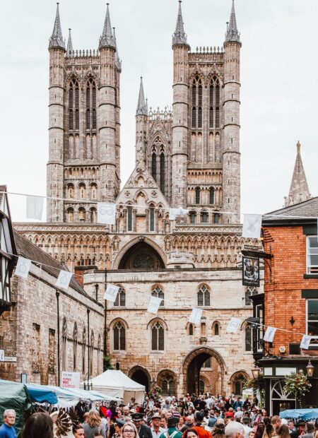 Lincoln cathedral dominates the photo, white flags are strung across the castle square and crowds flood a christmas market in the front
