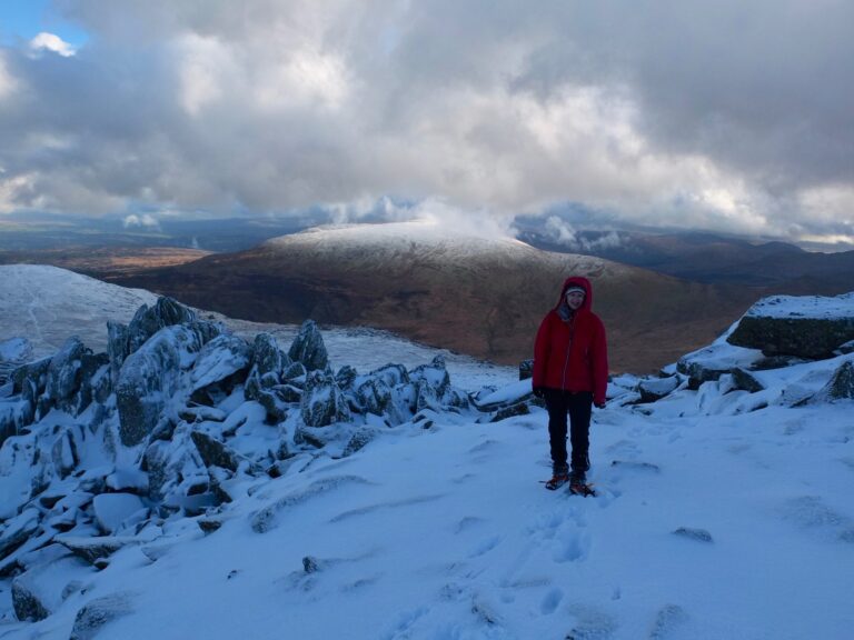 Alice stands in the snow oh an eco-friendly hike in wales