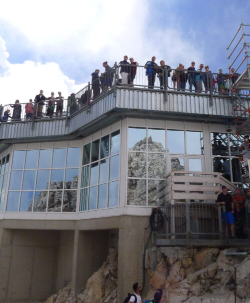 A group of tourists crowd the summit of Zugspitze