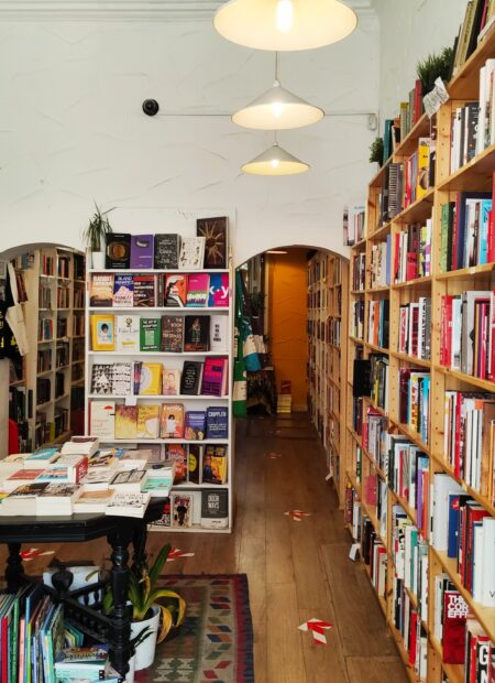 Arches sit in a white wall holding colourful, modern books