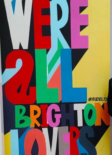 Colourful graffiti reads 'we are all brighton lovers'