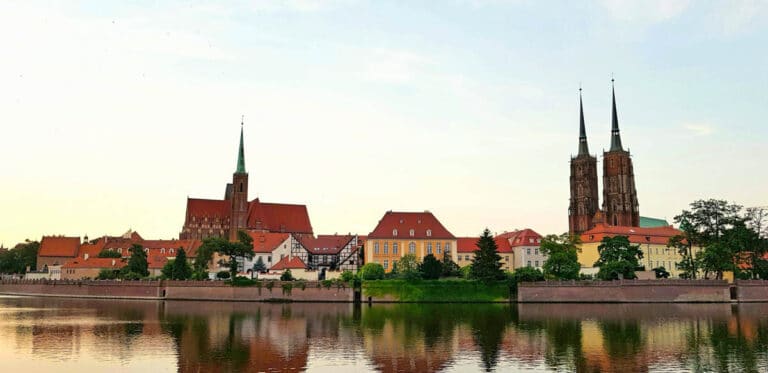 The island of Ostrow Tumski. The Cathedral of St John the Baptist towers rise in the background behind Wroclaw's green trees.