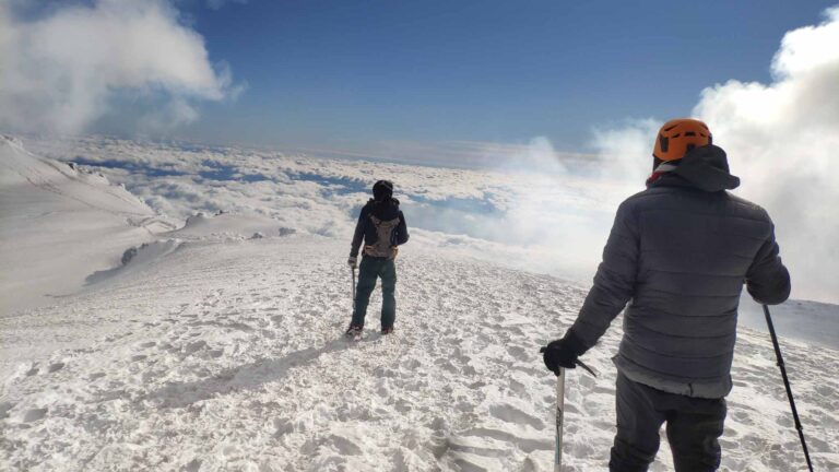 Two people dressed in warm layers at the summit of Villarrica