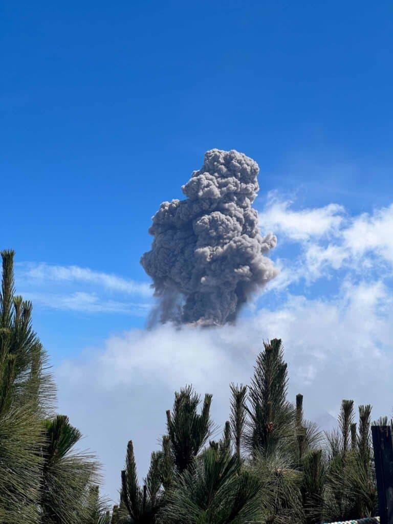 Volcan Fuego erupts behind a cloud